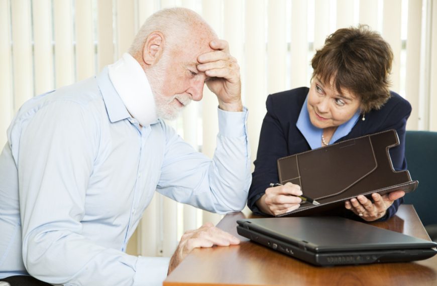 An old man with a neck brace talking to a lawyer in an office